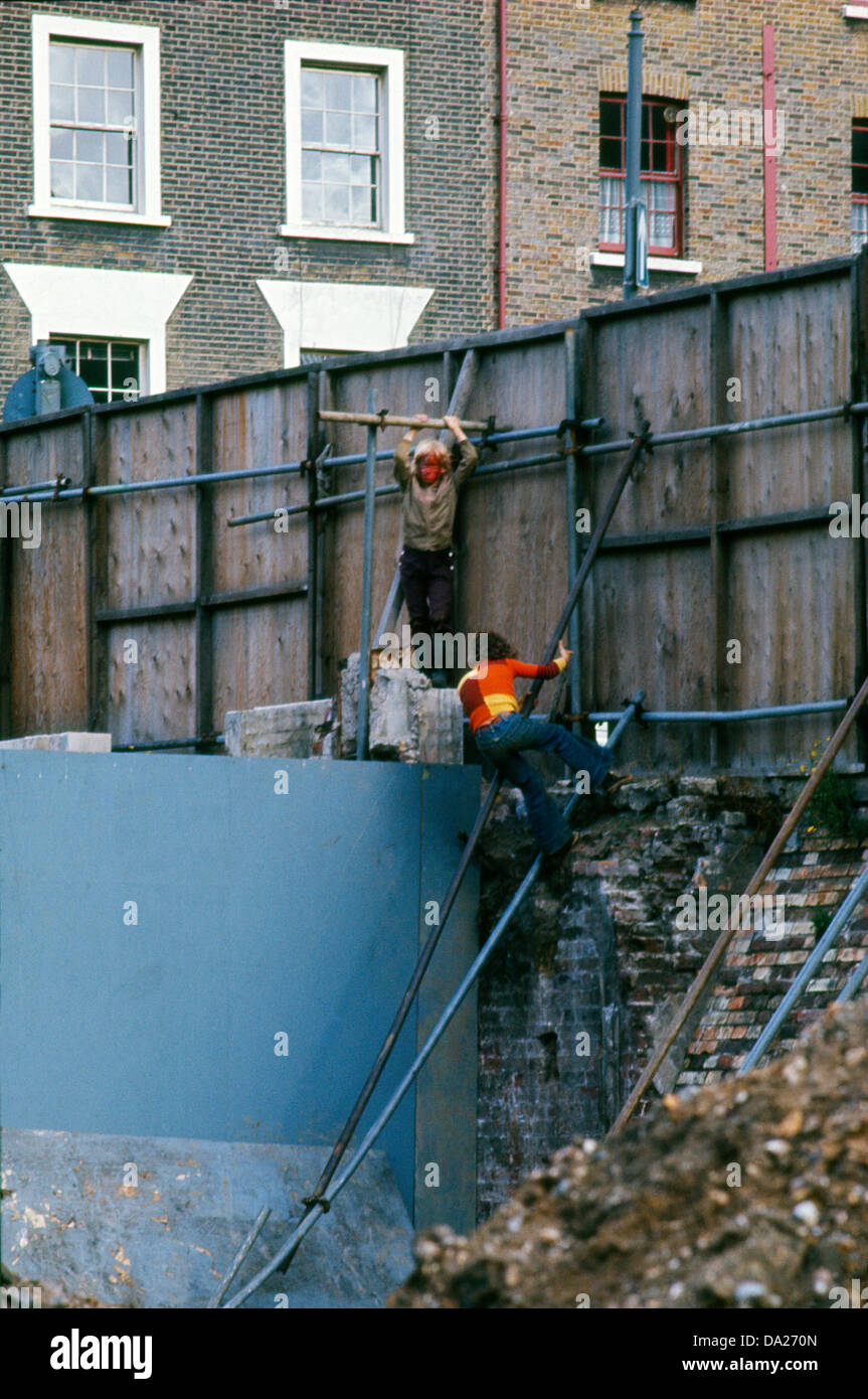 Boys poor children kids playing outside 1970s 70s climbing on Odham's demolition site scaffolding in Covent Garden London WC2 England Great Britain UK 1973     KATHY DEWITT Stock Photo