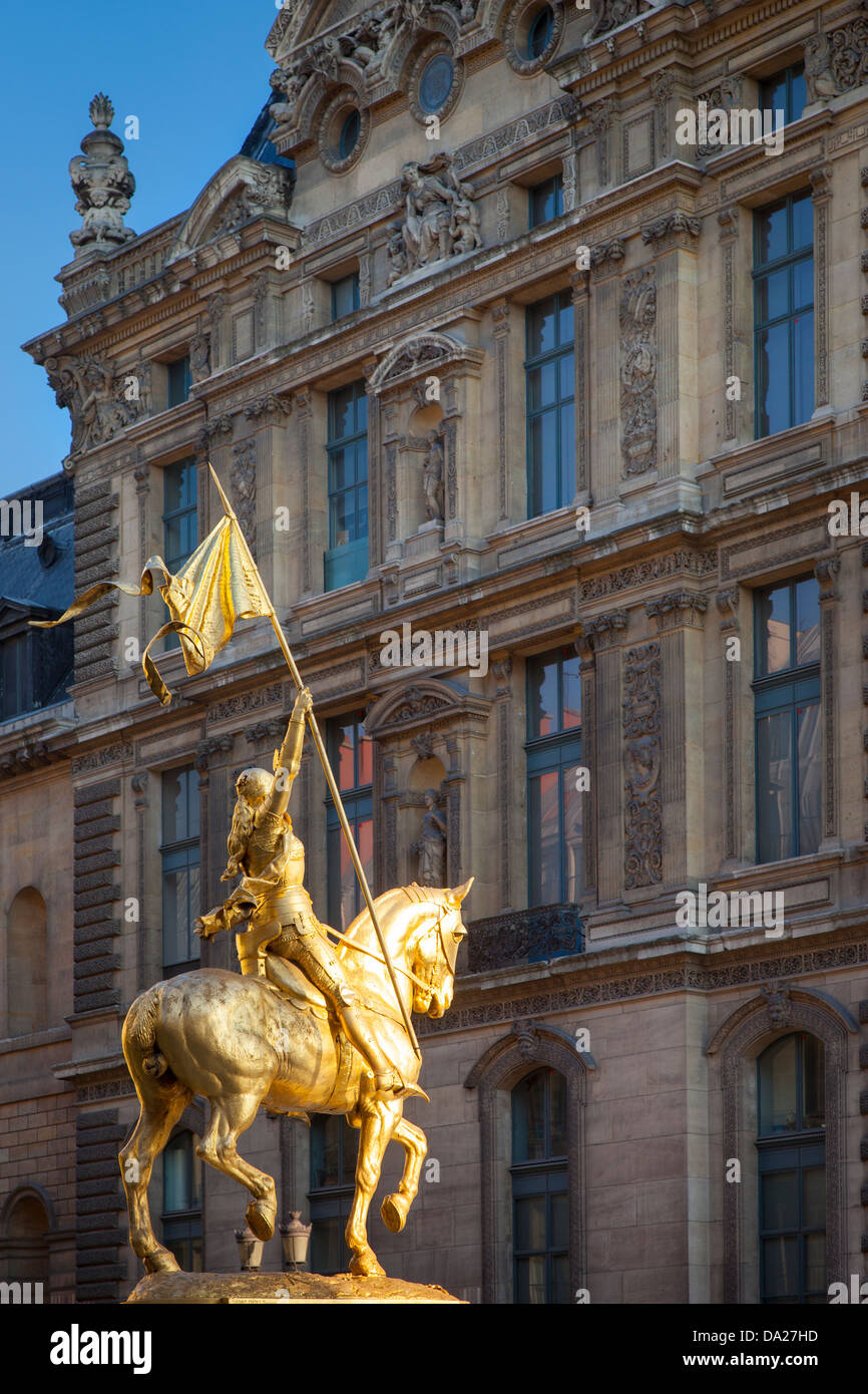 Golden statue of Joan of Arc (Jeanne d'Arc) with Musee du Louvre beyond