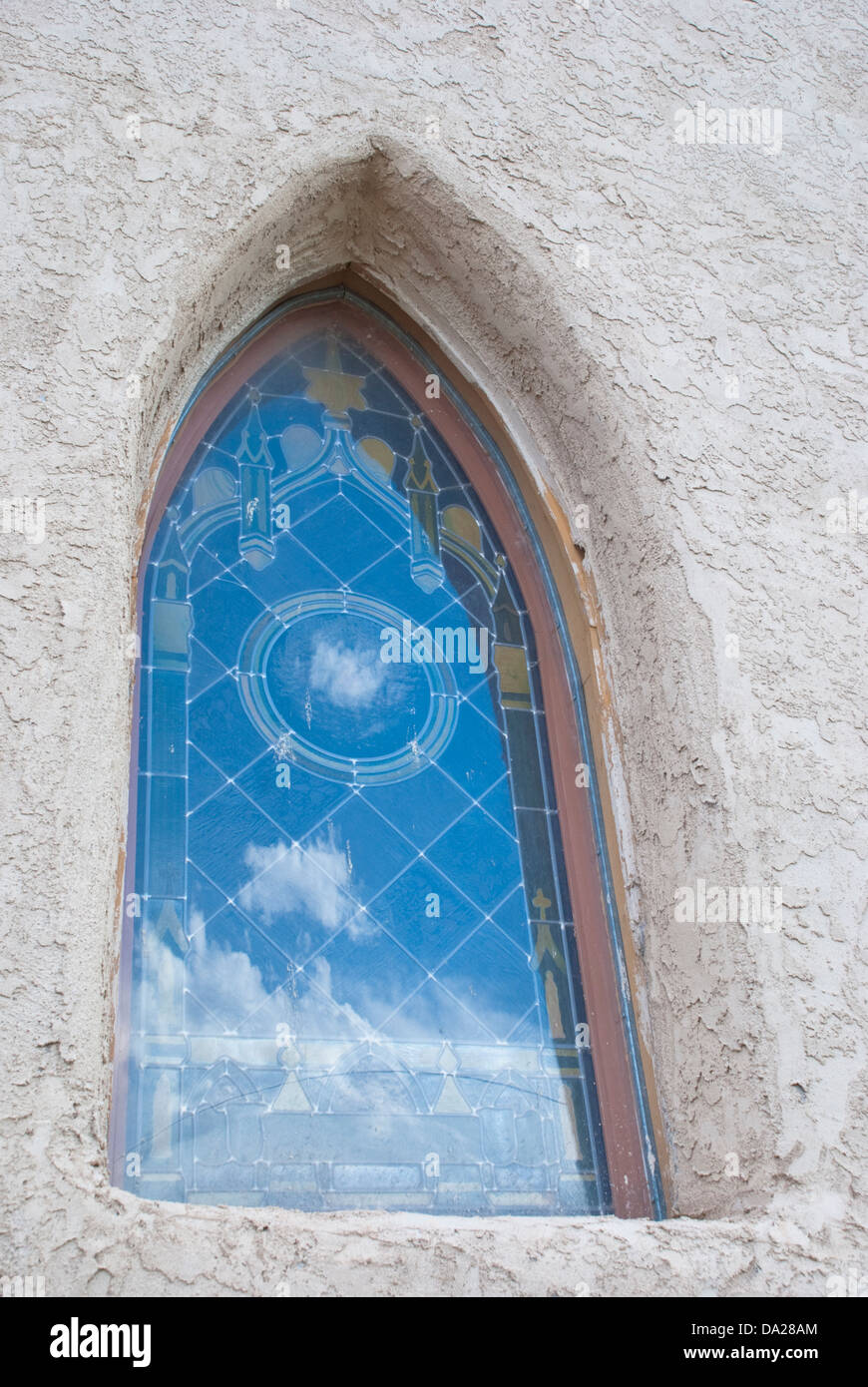 An ornate church window in Anton Chico reflects the beautiful blue New Mexico sky Stock Photo
