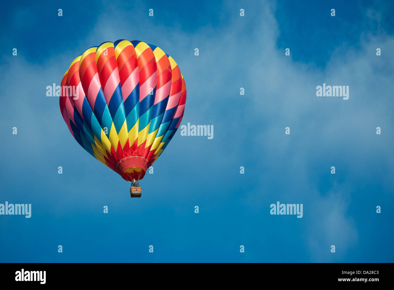 A brightly colored hot air balloon with a sky blue background Stock ...
