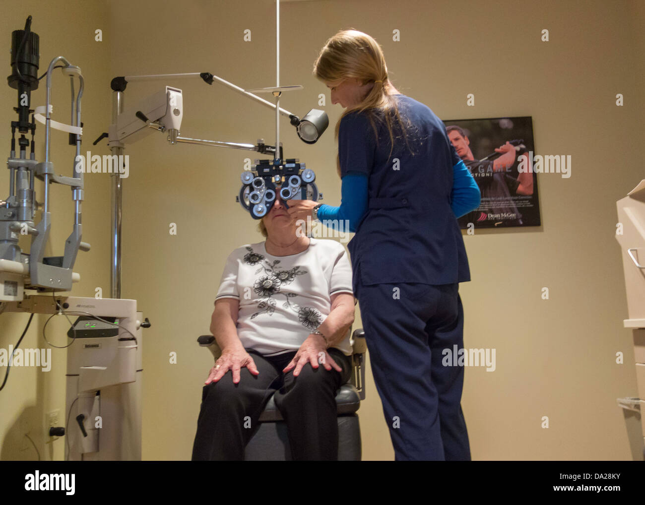 A female Ophthalomologist's Assistant refracts an elderly female patient during an eye exam. USA Stock Photo