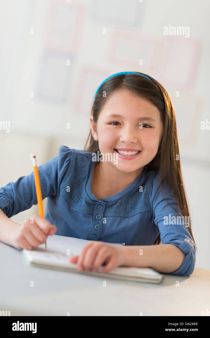 Portrait of schoolgirl (8-9) writing in notebook Stock Photo