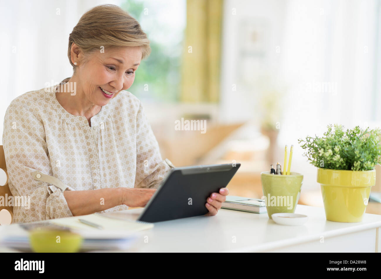 Senior woman using tablet pc at home Stock Photo