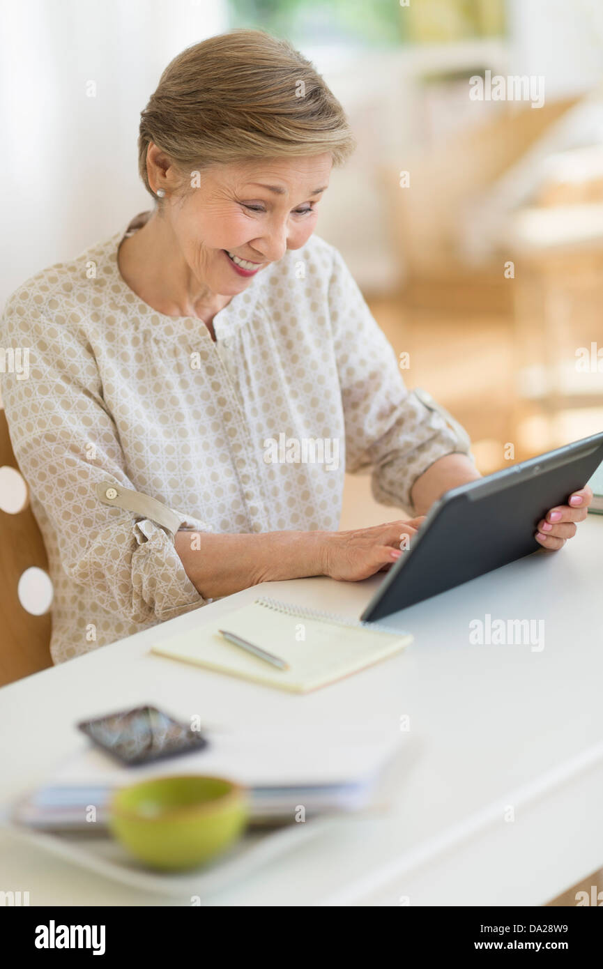 Senior woman using tablet pc at home Stock Photo