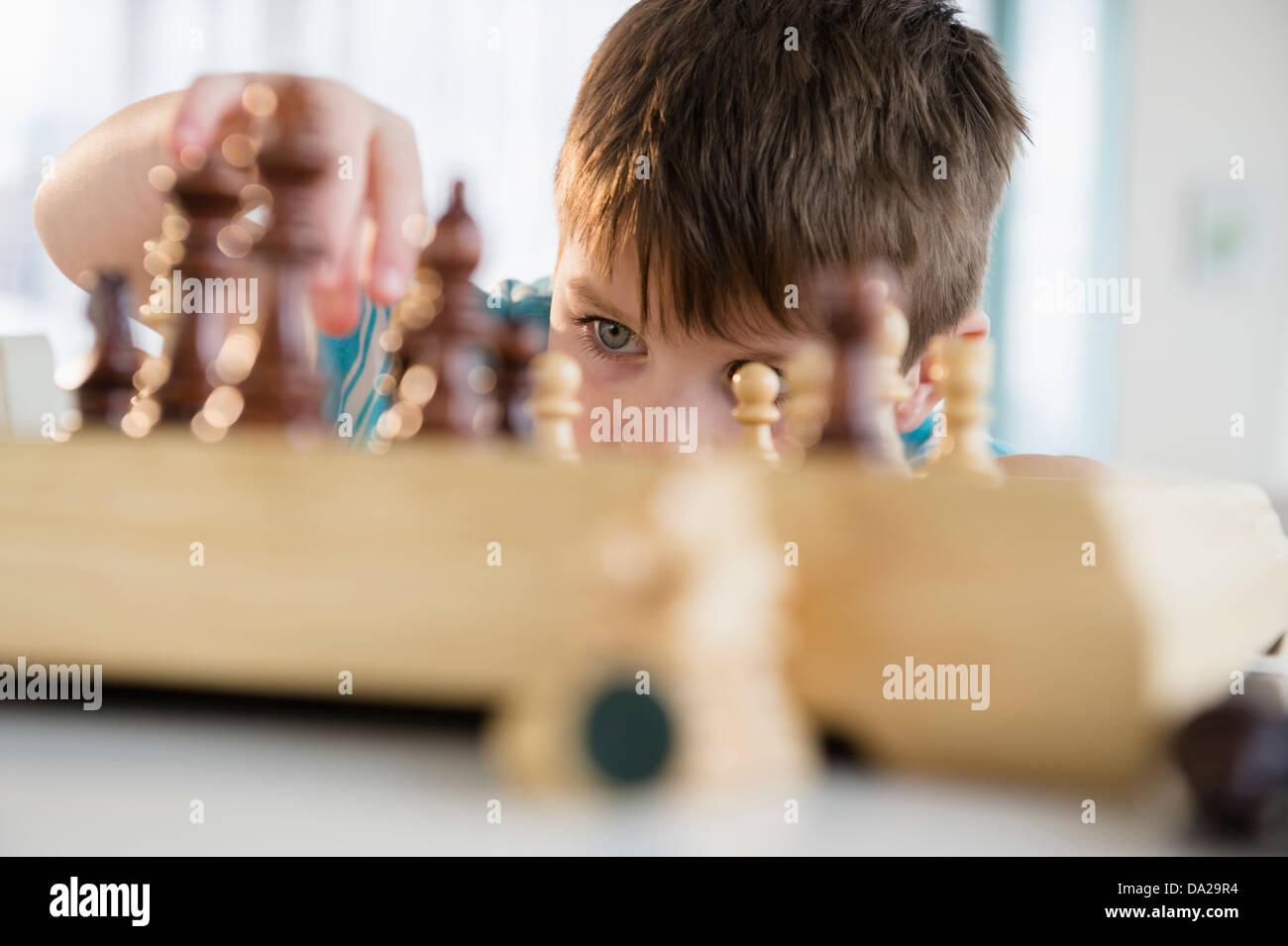 Boy (4-5) playing chess Stock Photo