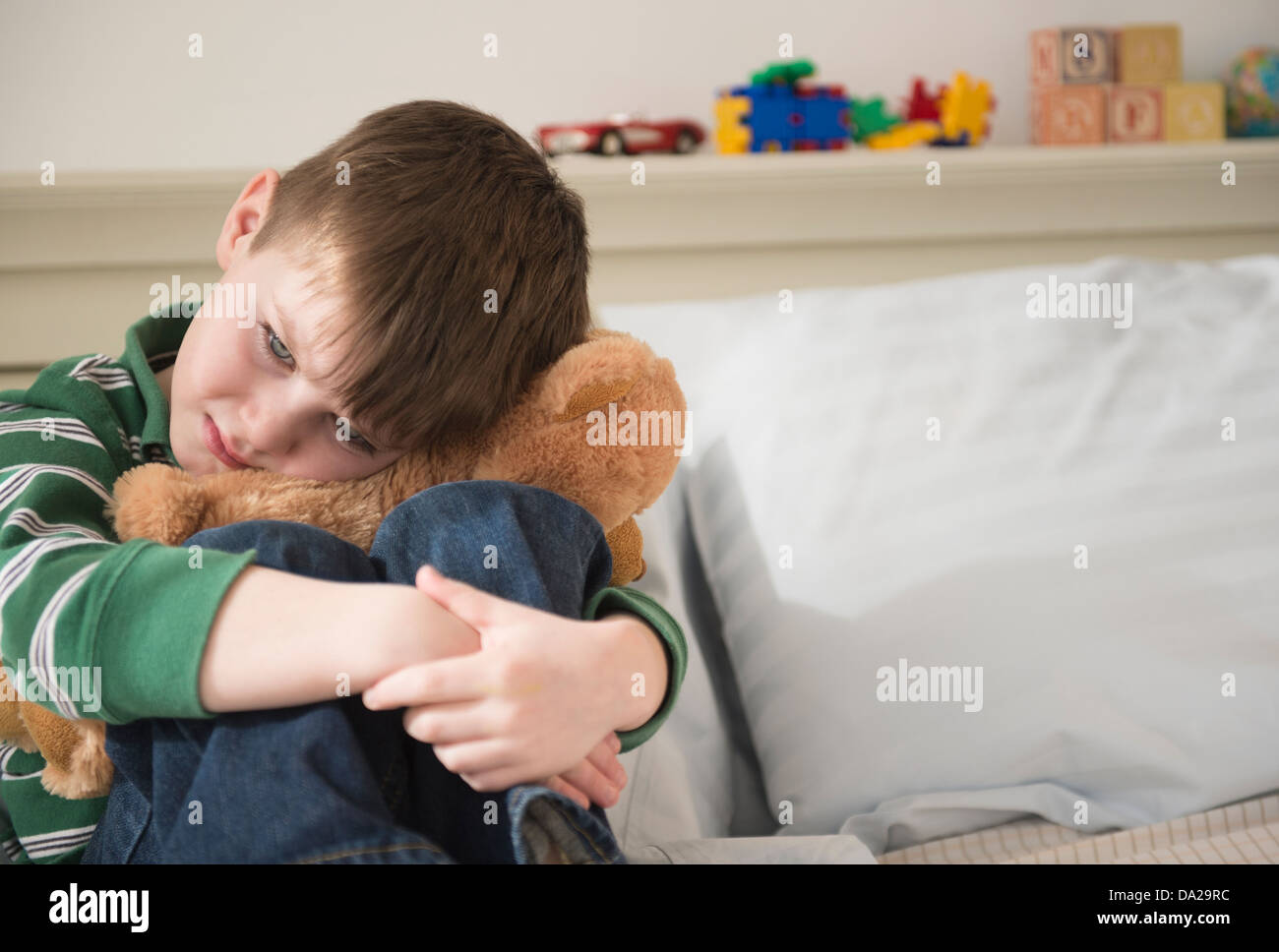 Portrait of sad boy (4-5) snuggling teddy bear Stock Photo - Alamy