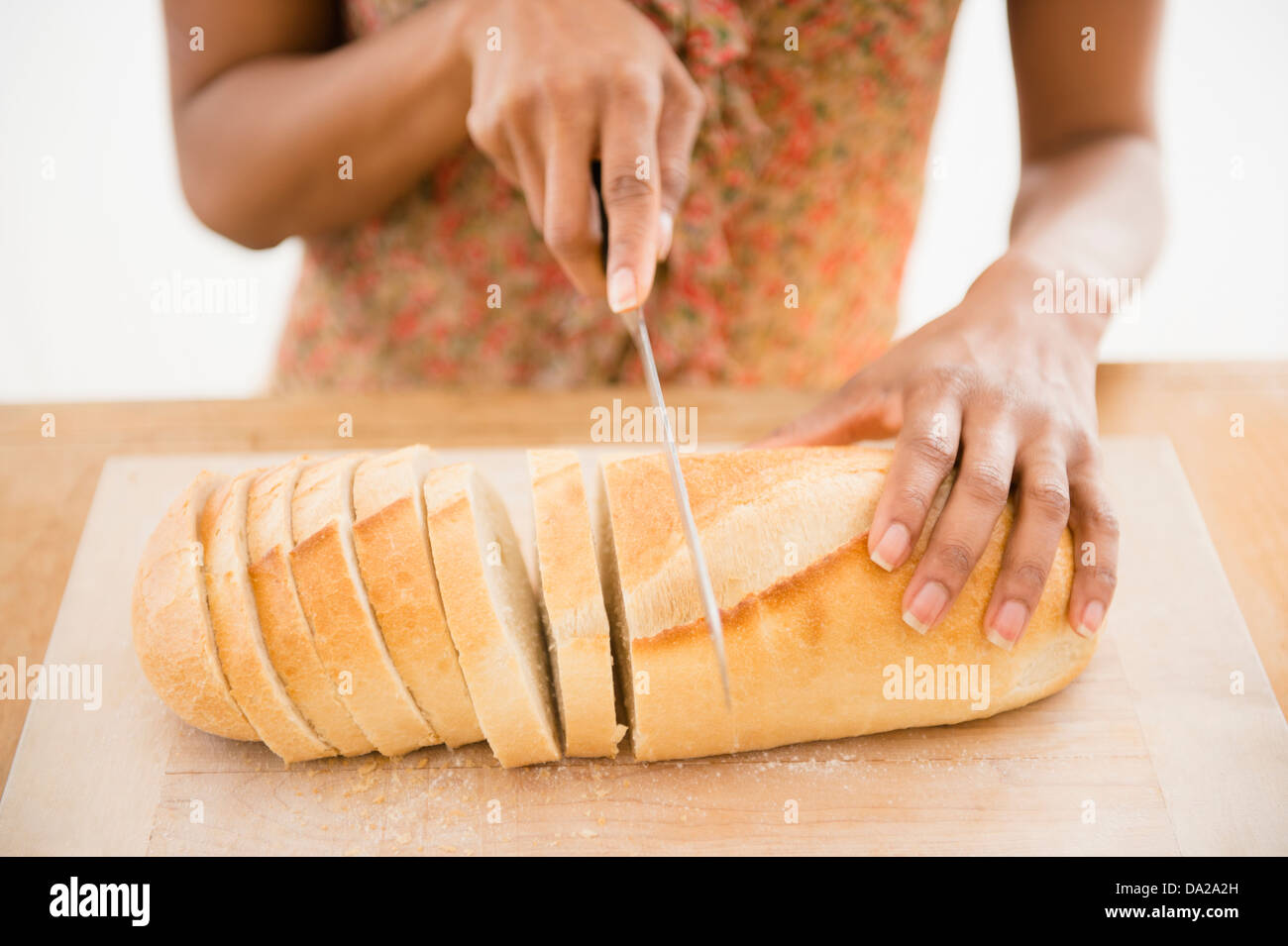 Close up of womaqn's hand cutting bread Stock Photo