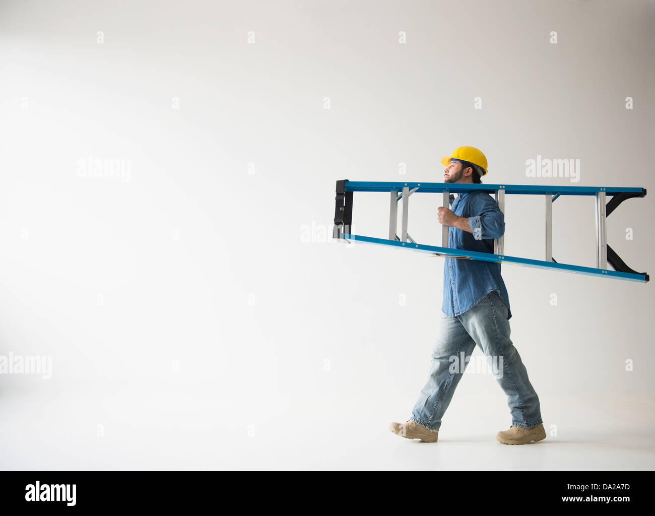Side view of man carrying ladder Stock Photo Alamy