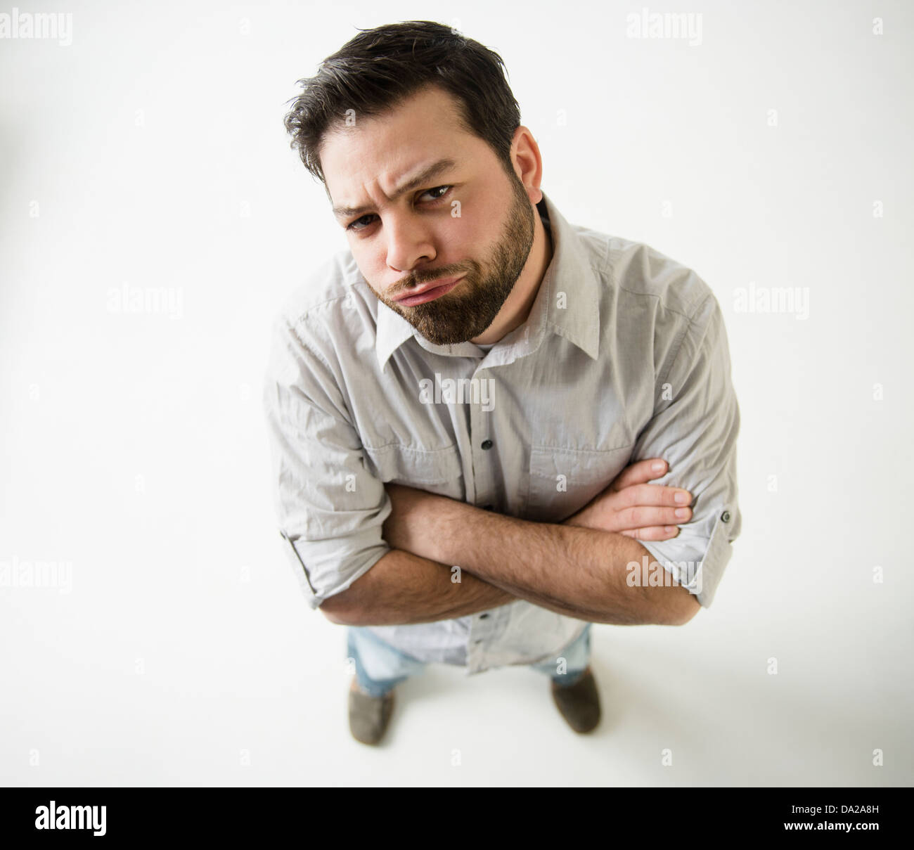 Elevated view of irritated man, arms crossed Stock Photo