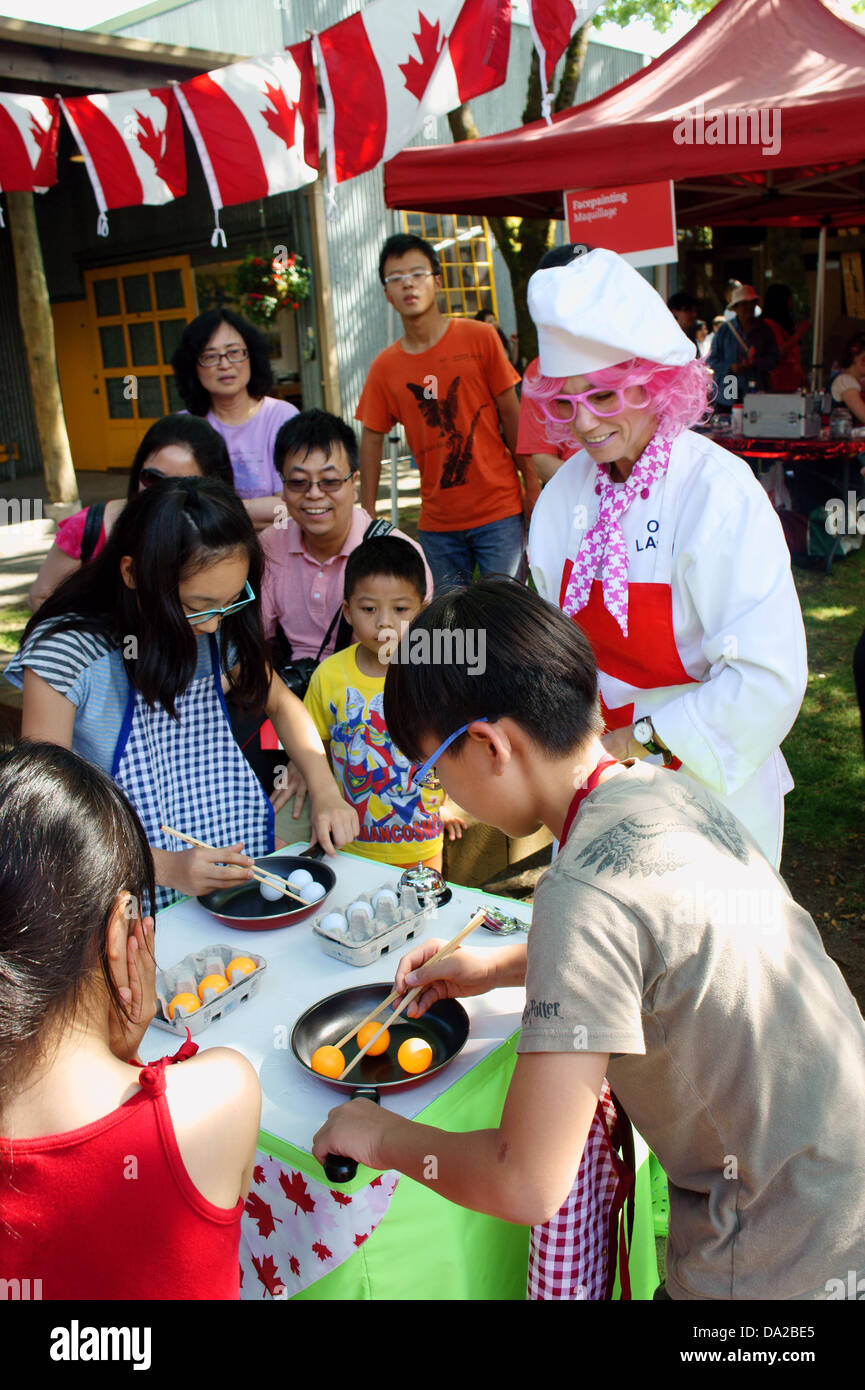 Children of Asian descent racing to pick up eggs with chopsticks at Canada Day celebrations on Granville Island in Vancouver, British Columbia, Canada Stock Photo