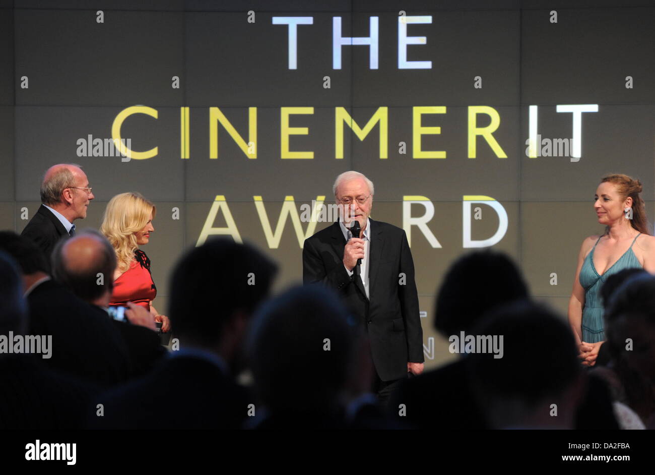 Munich, Germany. 01st July, 2013. British actor Michael Caine (C) stands next to director of Filmfest Muenchen, Diane Iljine (R), presenter Jessica Kastrop (2-L) and cultural manager of Munich, Hans-Georg Kueppers (L), during the award ceremony of the CineMerit Award at the Munich Film Festival in Munich, Germany, 01 July 2013. The festival has been awarding the CineMerit Award since 1997. Photo: TOBIAS HASE/dpa/Alamy Live News Stock Photo