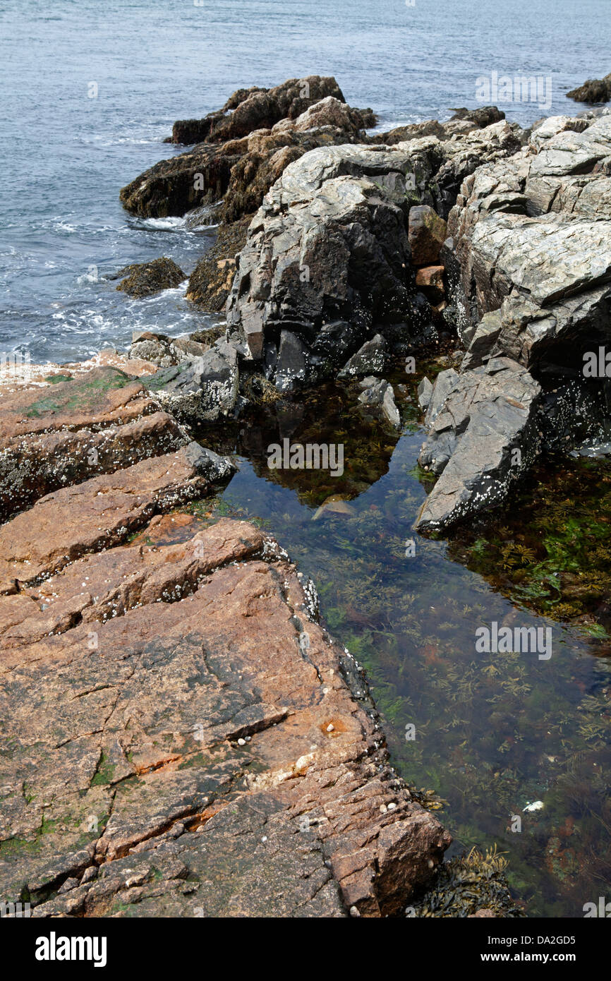 Rocks and tidal pool along the Atlantic coast shoreline Stock Photo