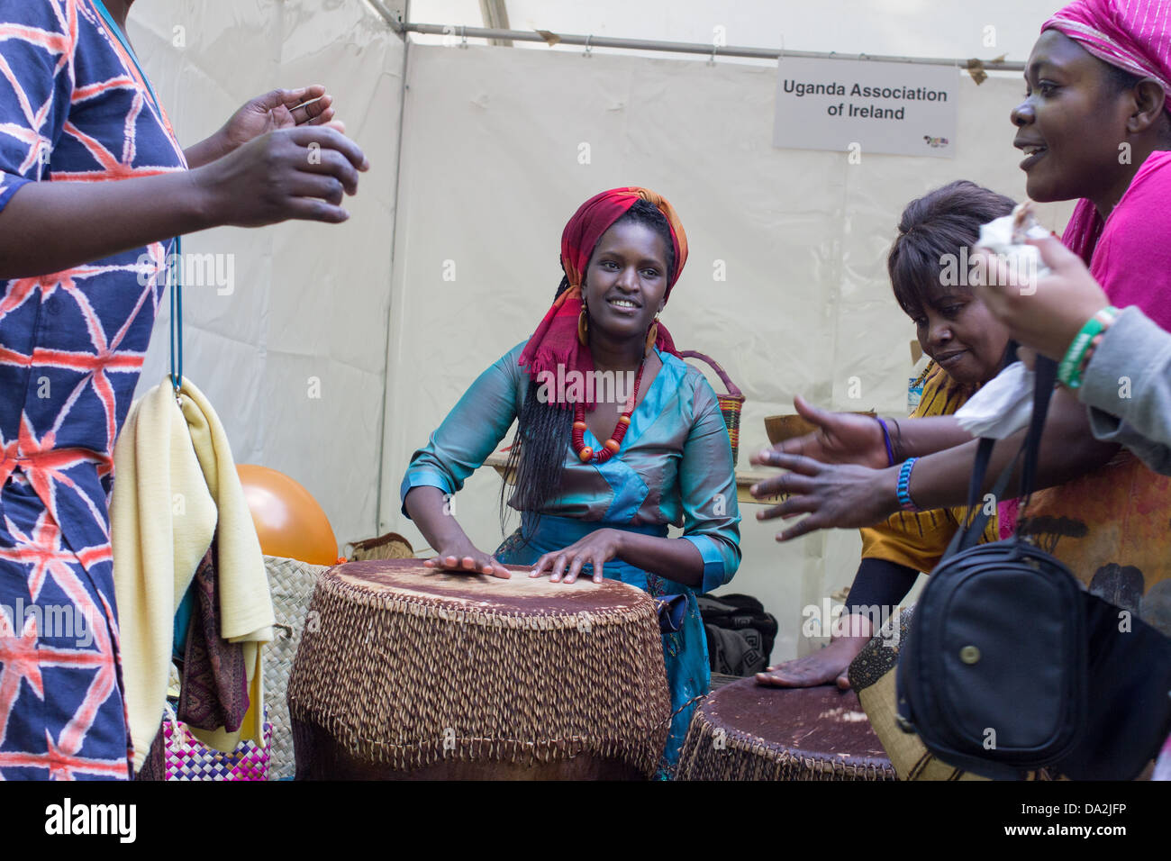 A woman plays on a large drum during festival called Africa Day. Stock Photo