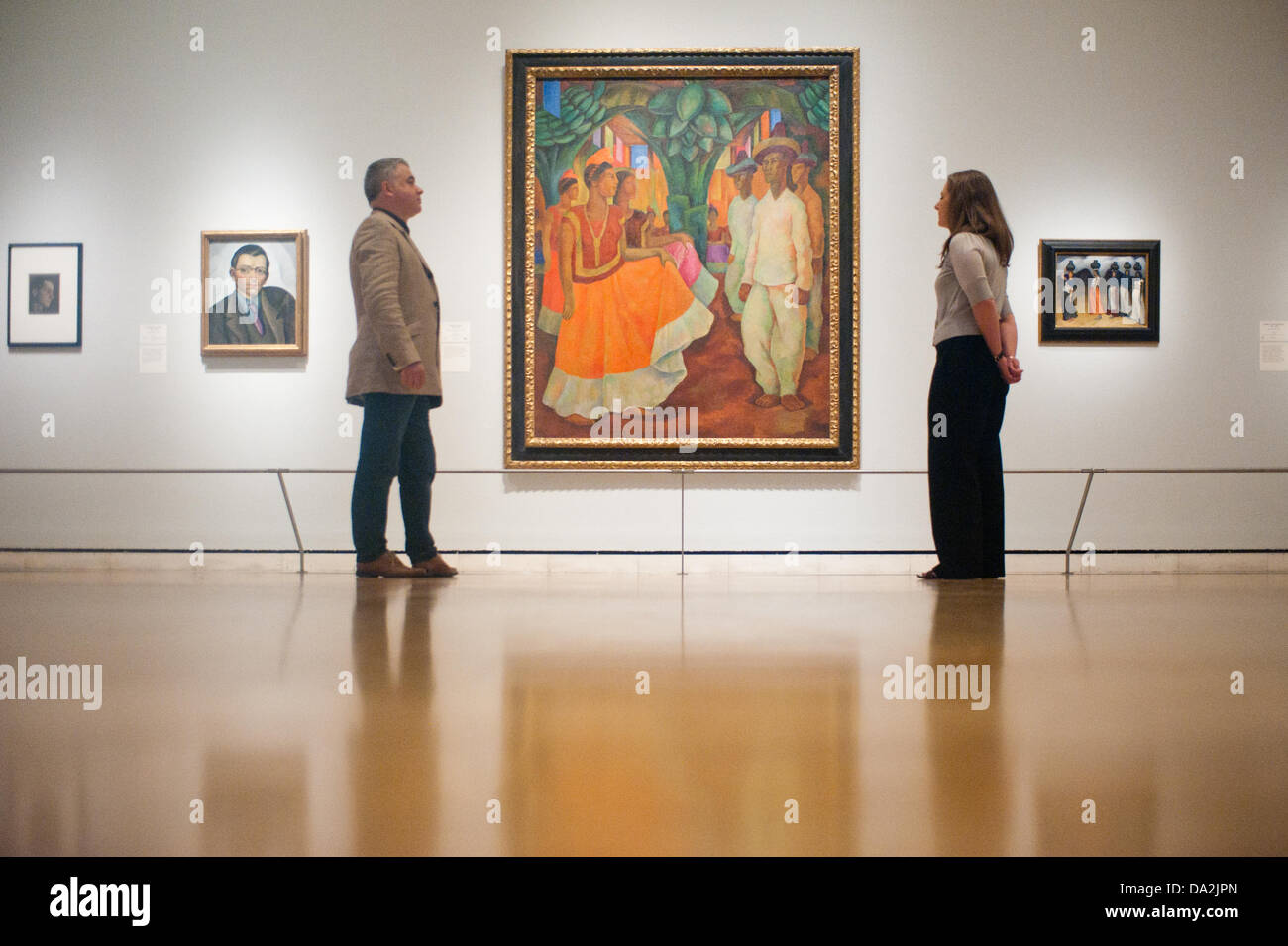 London, UK - 2 July 2013: curator Dr Adrian Locke and a Royal Academy of Arts employee stand next to a work by Diego Rivera entitled 'Dance in Tehuantepec, 1928' at the exhibition 'Mexico: A Revolution in Art, 1910–1940' which opens on the 6th of July. The show features over 120 paintings and photographs and examines the intense period of artistic creativity that took place in Mexico at the beginning of the 20th century. Credit:  Piero Cruciatti/Alamy Live News Stock Photo
