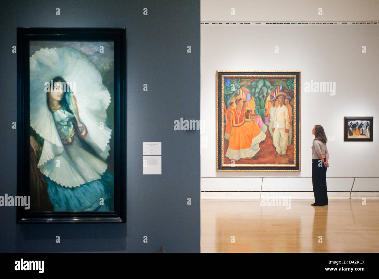 London, UK - 2 July 2013: A Royal Academy of Arts employee stands next to a work by Diego Rivera entitled 'Dance in Tehuantepec, 1928' at the exhibition 'Mexico: A Revolution in Art, 1910–1940' which opens on the 6th of July. The show features over 120 paintings and photographs and examines the intense period of artistic creativity that took place in Mexico at the beginning of the 20th century.  On the left 'Woman from Tehuantepec, 1914' by Saturnino Herran. Credit:  Piero Cruciatti/Alamy Live News Stock Photo