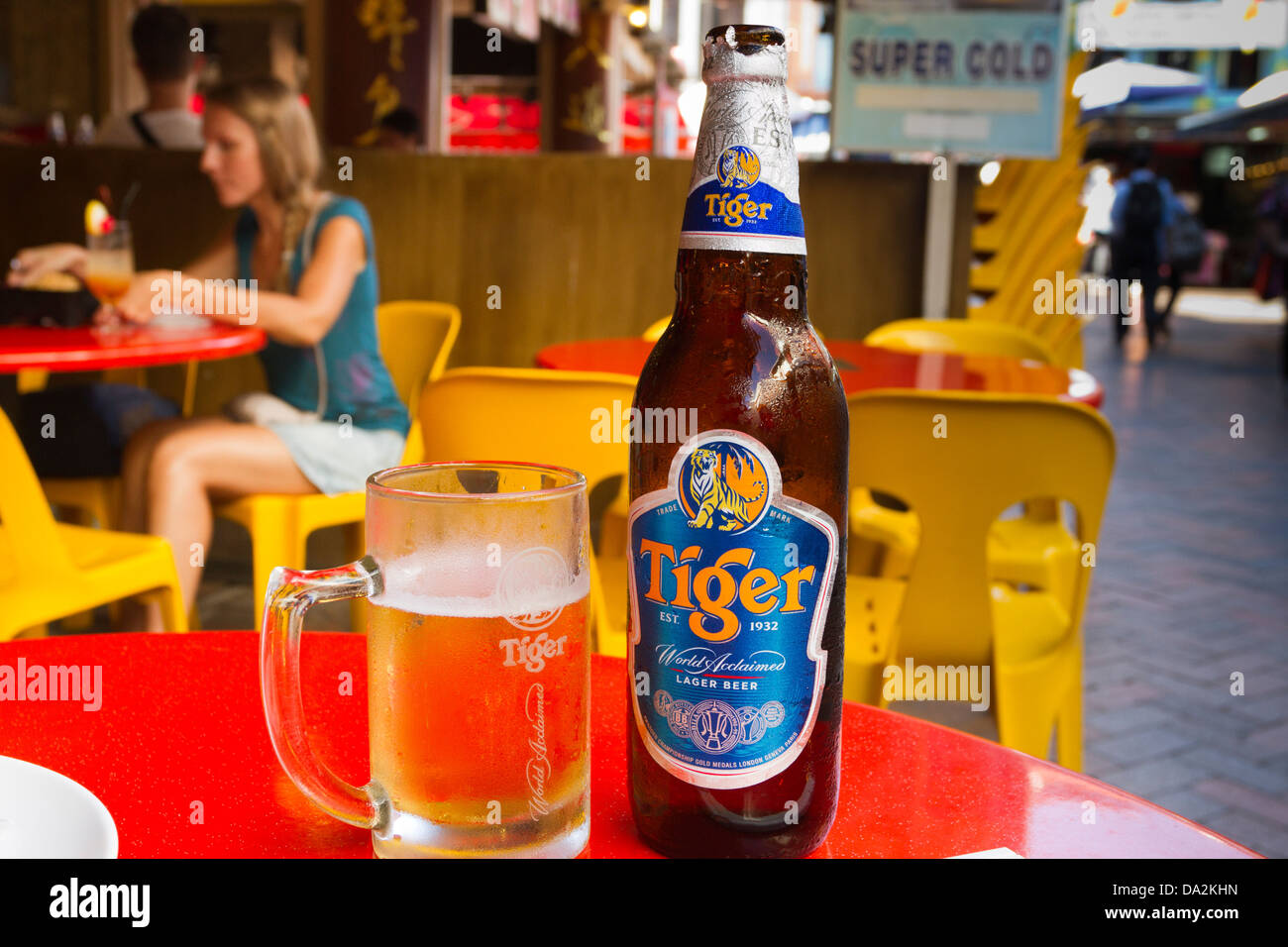 Bottle and glass of cold Tiger beer on a red table at a Chinese restaurant, Chinatown, Singapore Stock Photo