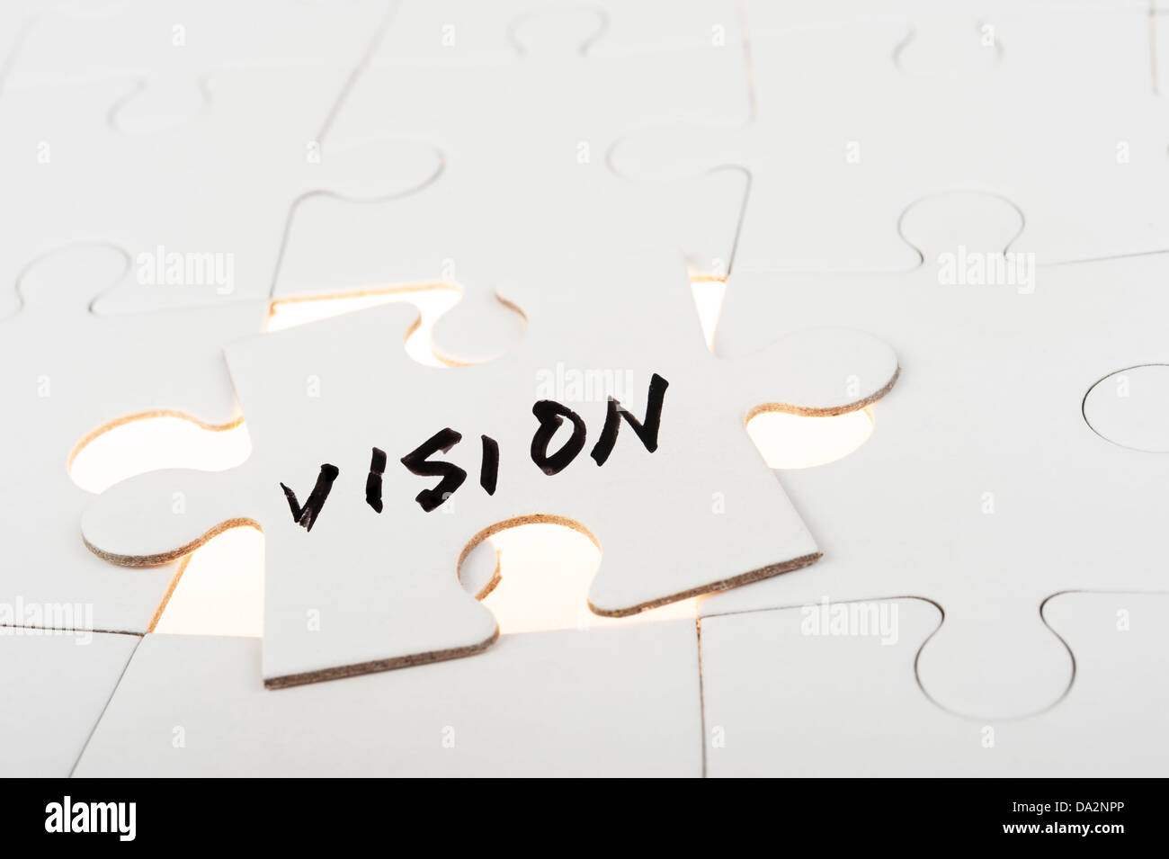 Vision word written on a piece of puzzle over group of paper jigsaw puzzles Stock Photo
