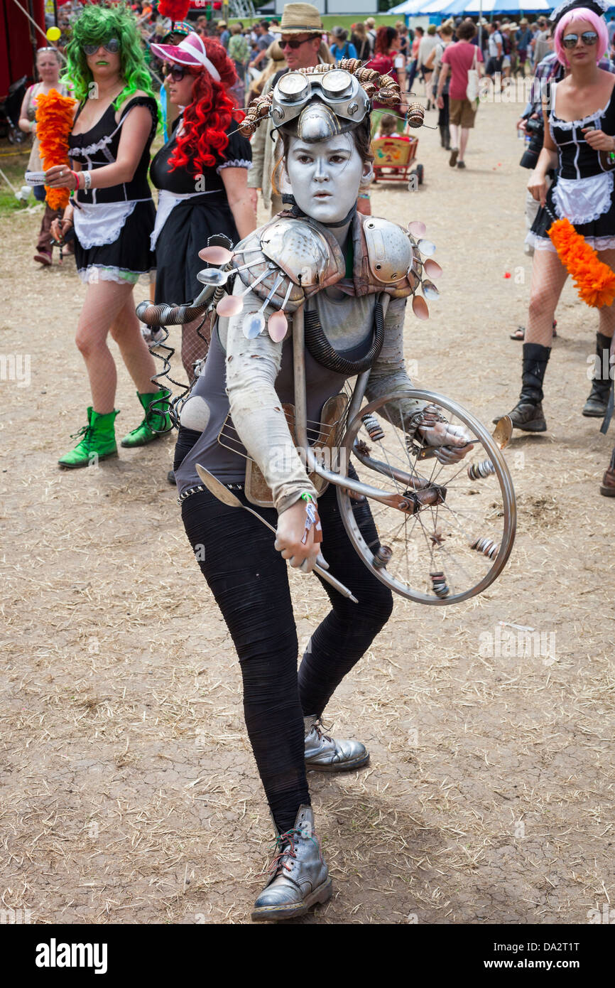 GLASTONBURY FESTIVAL, UK- JUNE 30 2013 : Walkabout performer in a futuristic outfit plays an improvised percussion instrument Stock Photo