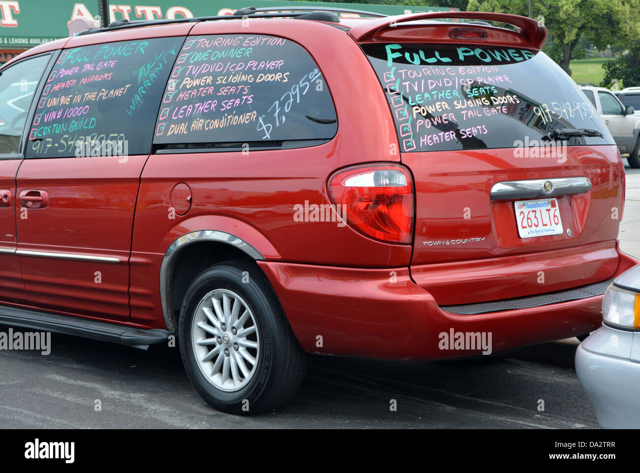 A car for sale with advertising written on it windows in the Bushwick