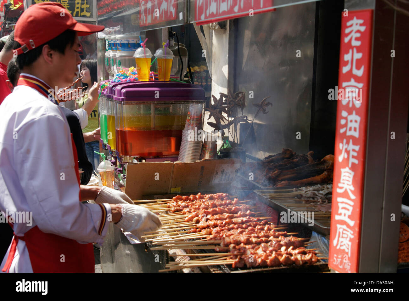 Man grilling meat on sticks, Wangfujing  street, Beijing, China Stock Photo