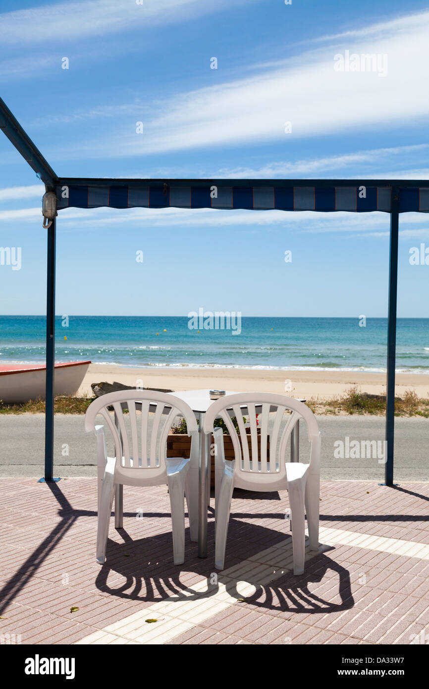 beach cafe tables chairs unoccupied awning Stock Photo