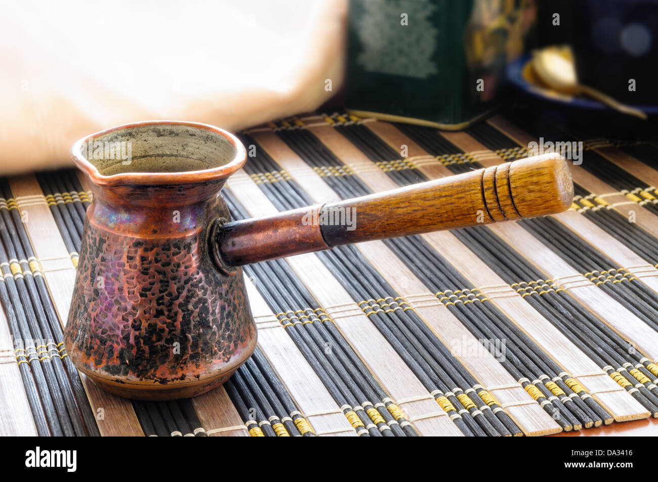 An old Ibrik. The Ibrik is a Turkish coffee pot in copper, with a wooden handle Stock Photo