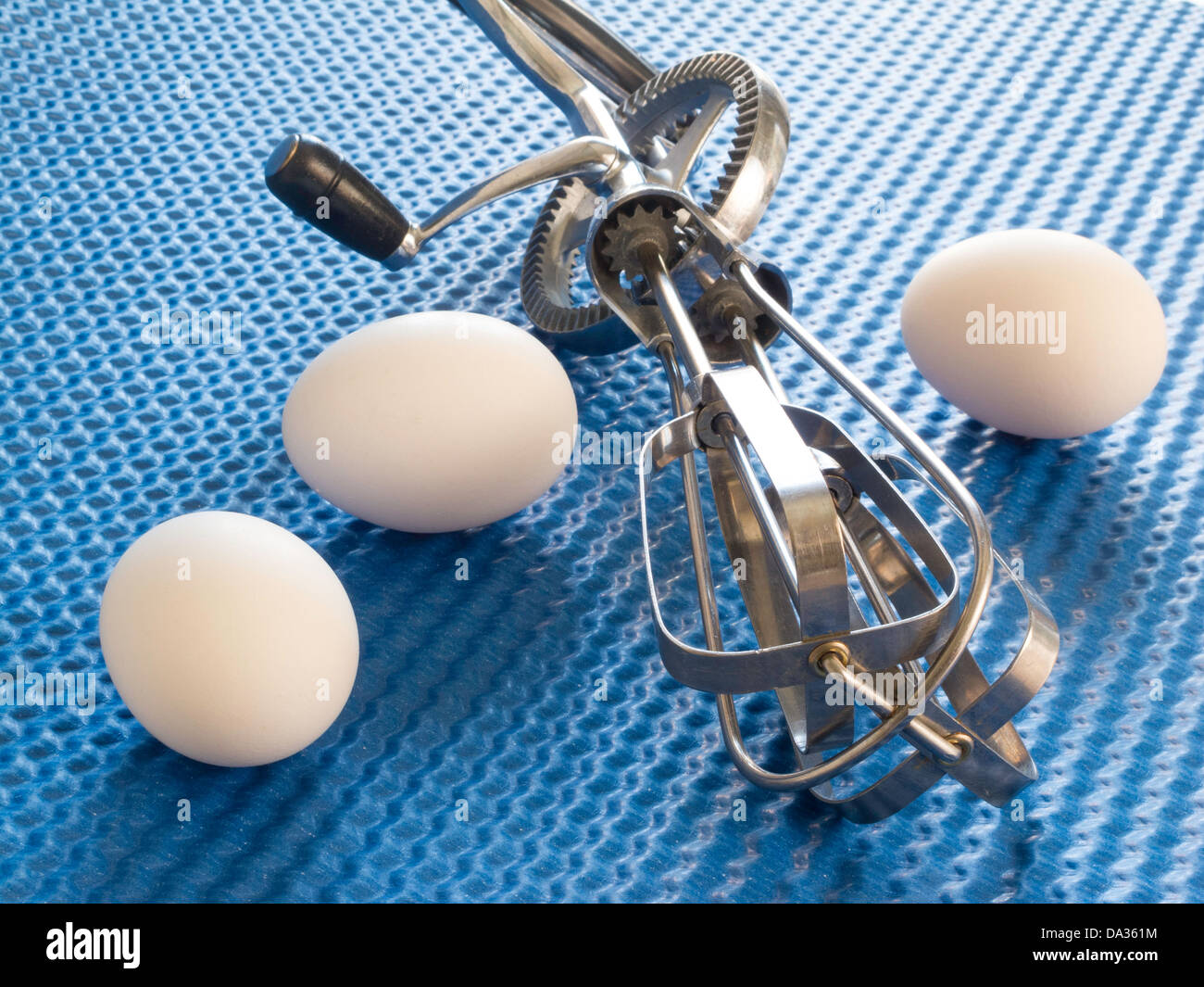 https://c8.alamy.com/comp/DA361M/three-eggs-with-vintage-rotary-hand-beater-on-blue-background-DA361M.jpg