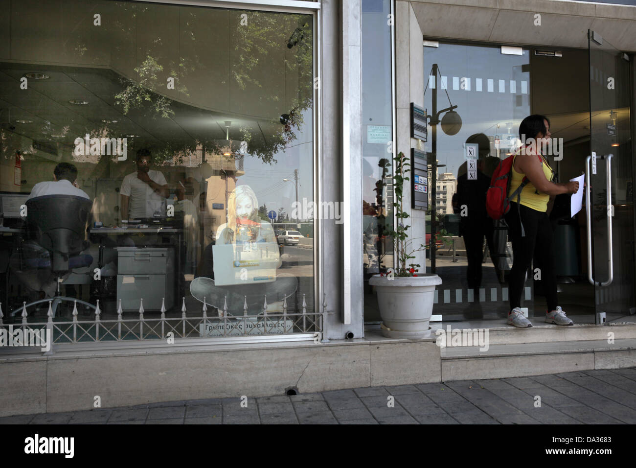 Cyprus, Nicosia. 02nd July, 2013. A woman leaves from a bank of Cyprus in capital Nicosia on July 2,2013.The Bank of Cyprus on Tuesday approved a voluntary redundancy scheme which will see 1,000 employees taking compensation for early retirement. Credit:  Yiannis Kourtoglou/Alamy Live News Stock Photo