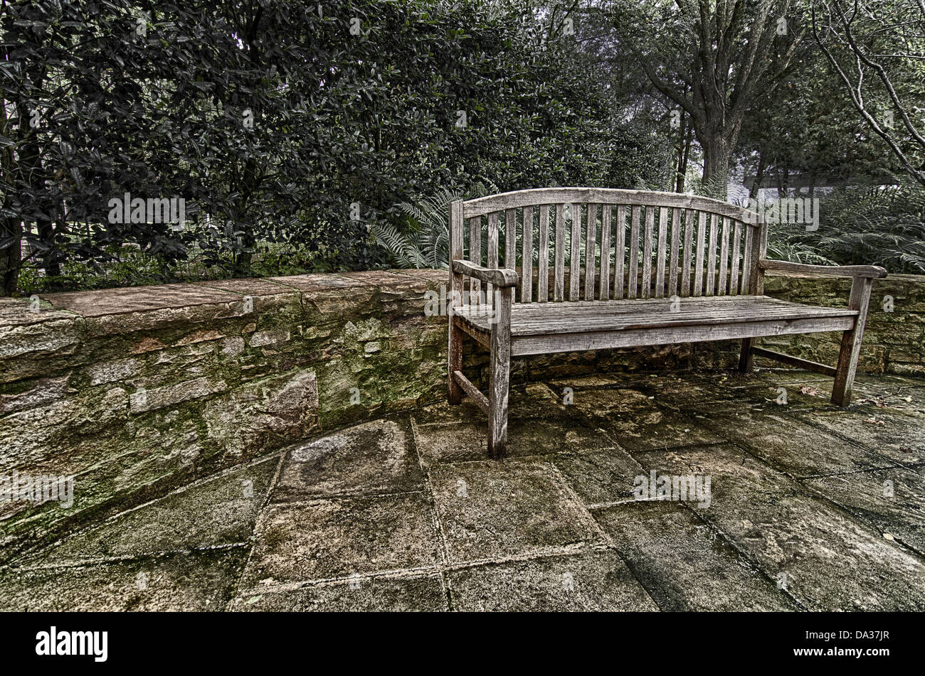 This image is a wooden bench in a garden. Stock Photo