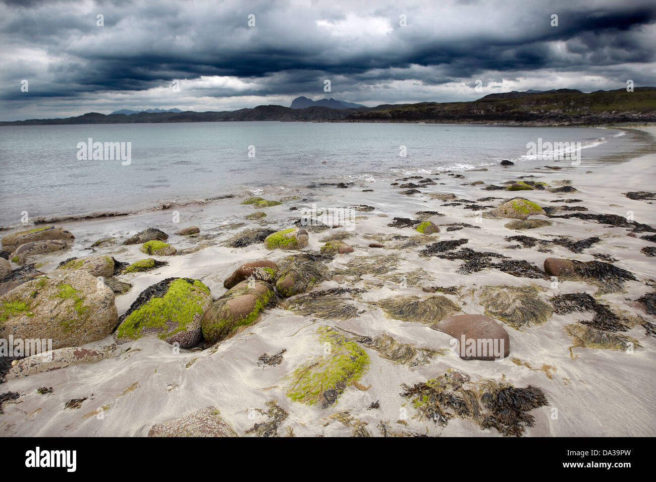 Pebbles on Garvie Beach under a dramatic dark sky, Garvie Bay, Enard Bay, Sutherland, Scotland