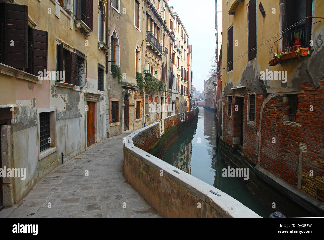 A small side Canal and colourful old buildings Venice Venetian Italy Stock Photo