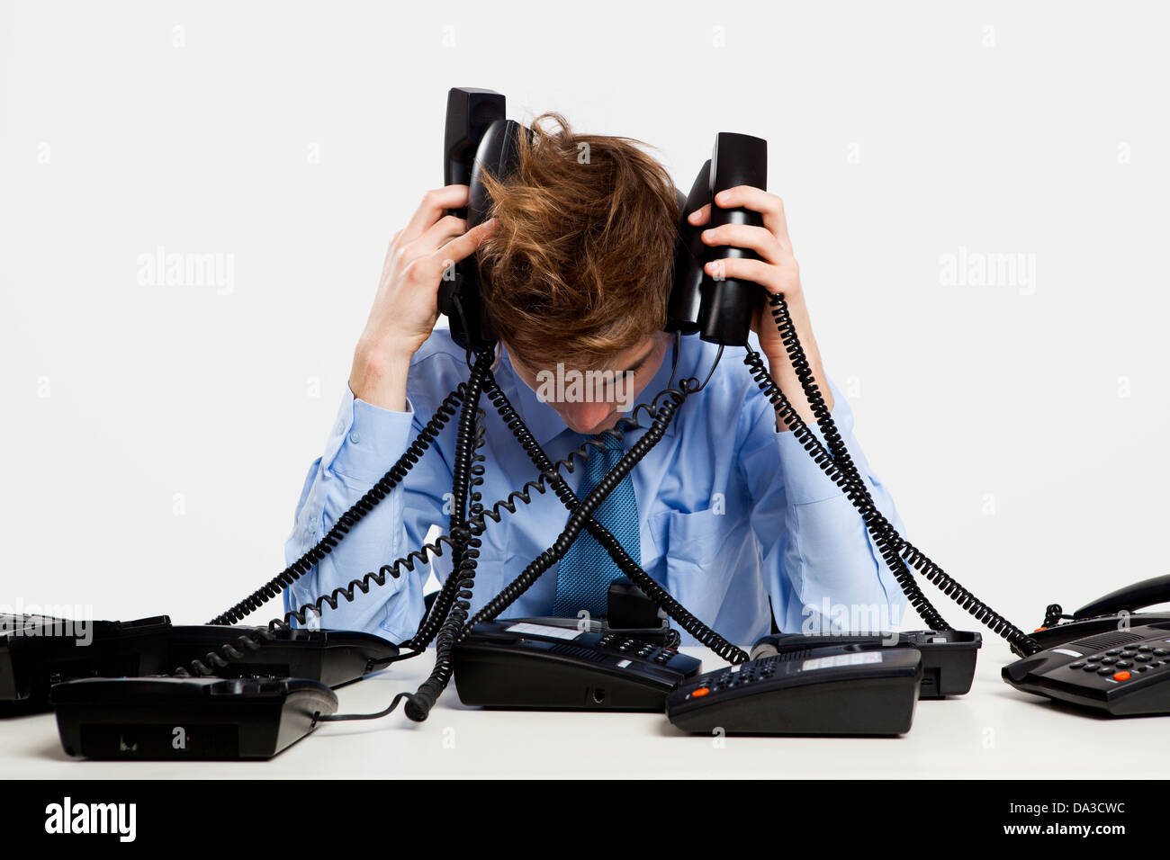 Man Using Many Phones young man in the office and answering several phones at the same time ...