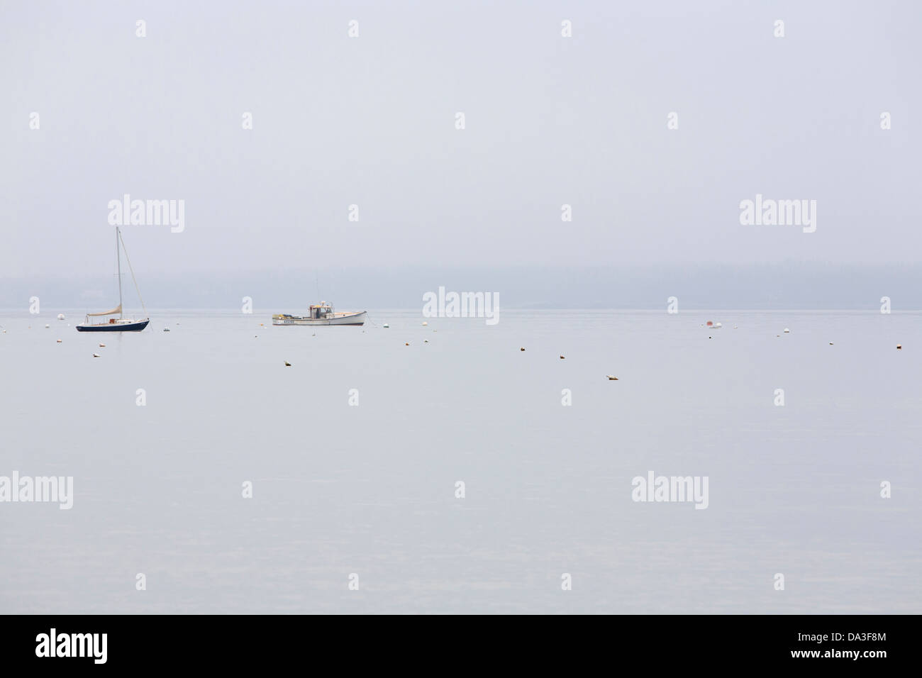 Fishing vessels at anchor in Seal Harbor during foggy weather. Stock Photo