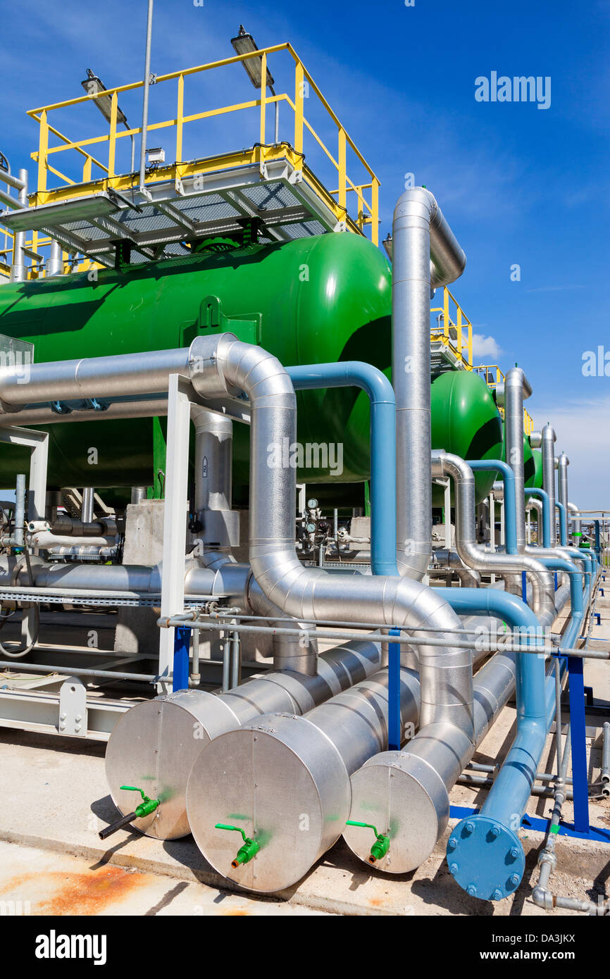 Piping and filters in a industrial facility against a cloudy blue sky Stock Photo