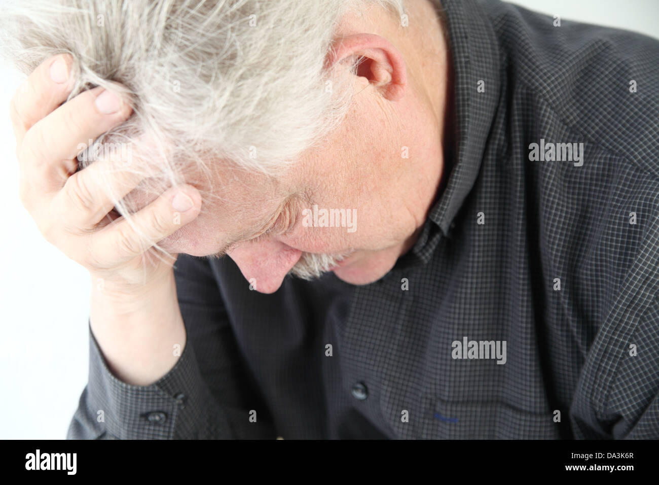 senior man bent over with grief or depression Stock Photo