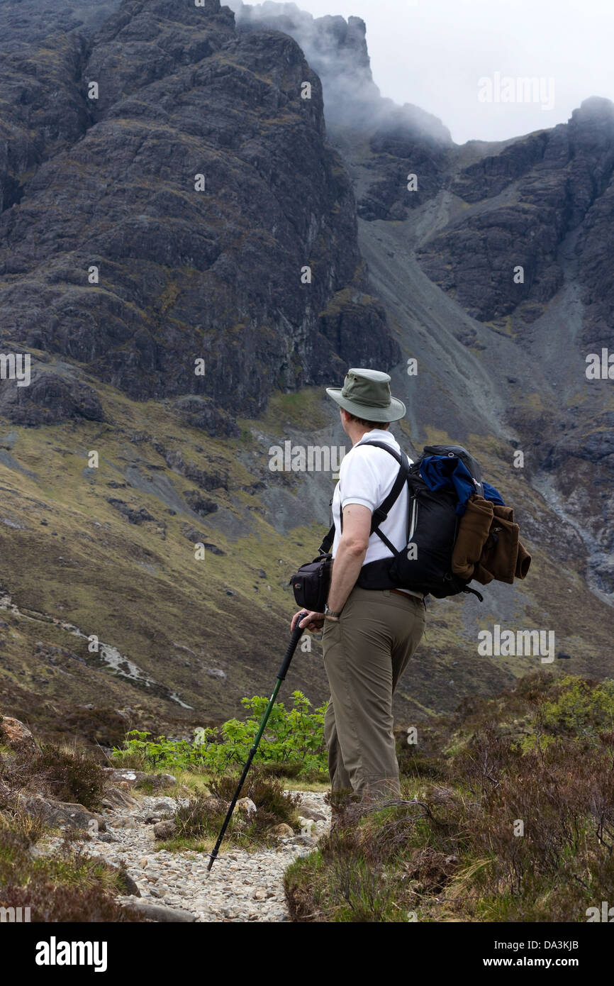 Hillwalker with sun hat and backpack on mountain path to Blaven, Isle of Skye, Scotland, UK Stock Photo