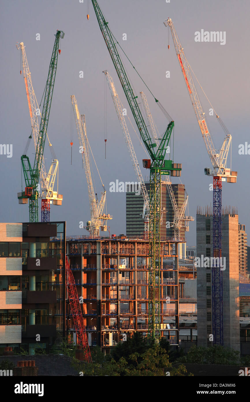 Construction cranes in north London, behind St Pancras station, at dusk, in England, UK Stock Photo
