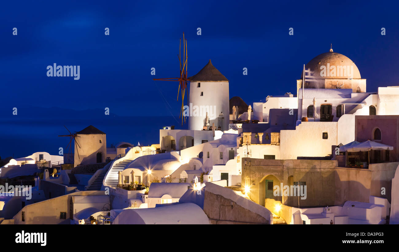 Traditional windmills at night in the town of Oia Santorini Greece Stock Photo