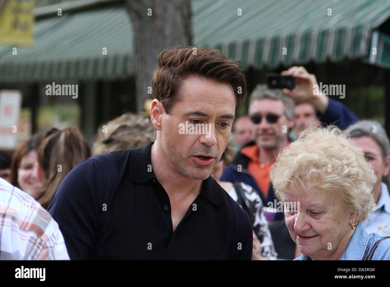 Robert Downey Jr signs his autograph for a fan during a break in filming 'The Judge.' Stock Photo