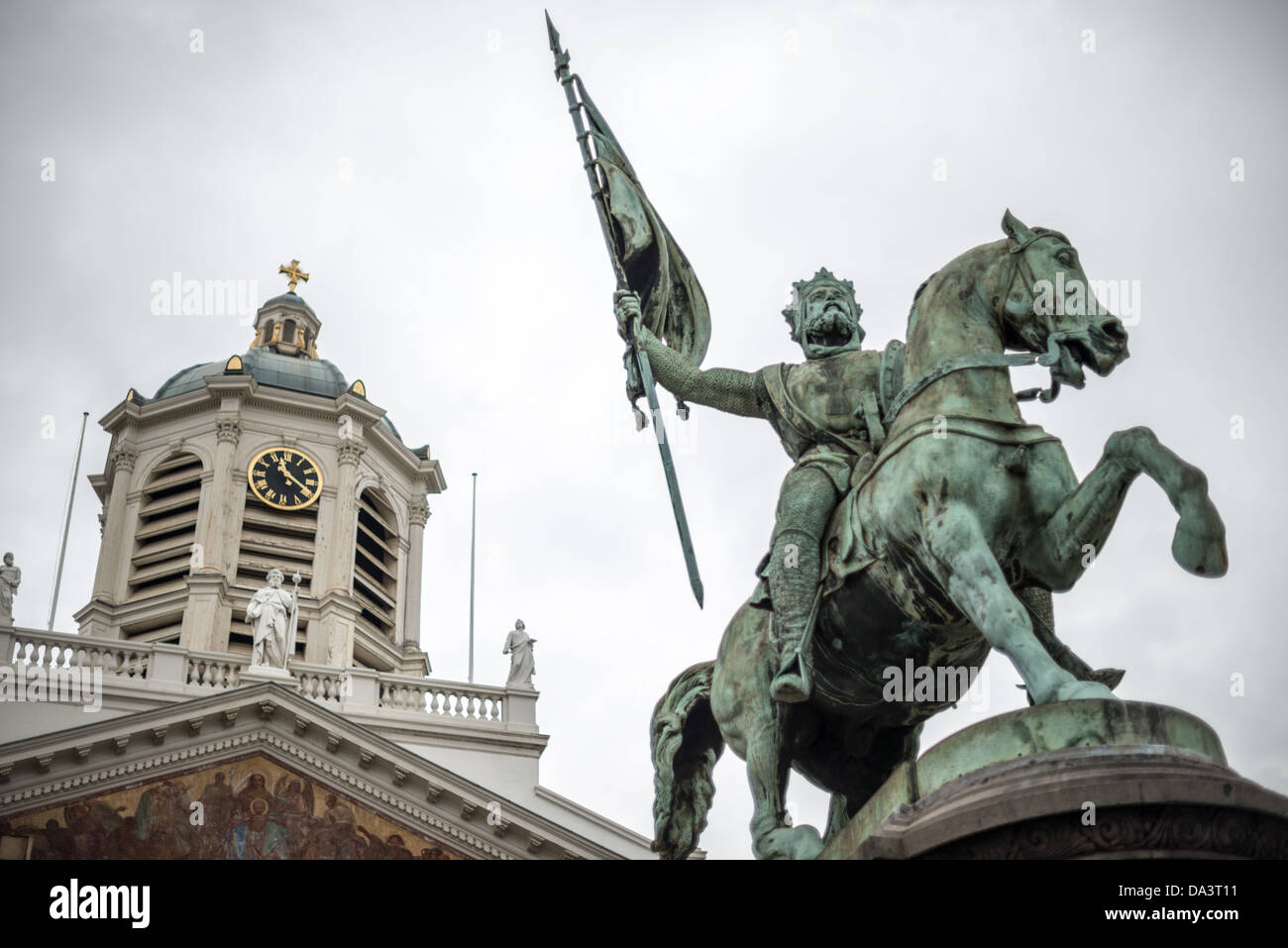 BRUSSELS, Belgium — The equestrian statue of Godfrey of Bouillon, leader of the First Crusade, dominates the center of Place Royale. Sculpted by Eugene Simonis in 1848, the monument depicts the medieval crusader who became the first ruler of the Kingdom of Jerusalem. The historic Church of Saint Jacques-sur-Coudenberg provides a dramatic backdrop for this prominent Belgian historical monument. Stock Photo