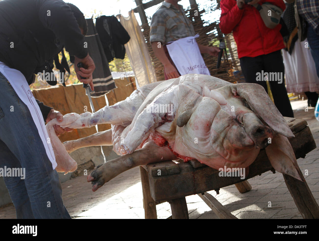 A slaughterman chops a pig in pieces during a traditional pork meat items fair in the Spanish island of Mallorca Stock Photo