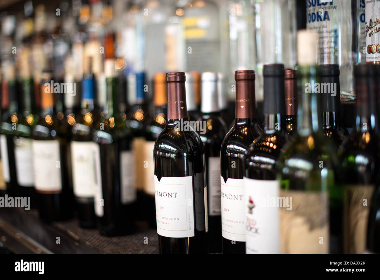 Wine bottles lined up behind a bar. Stock Photo