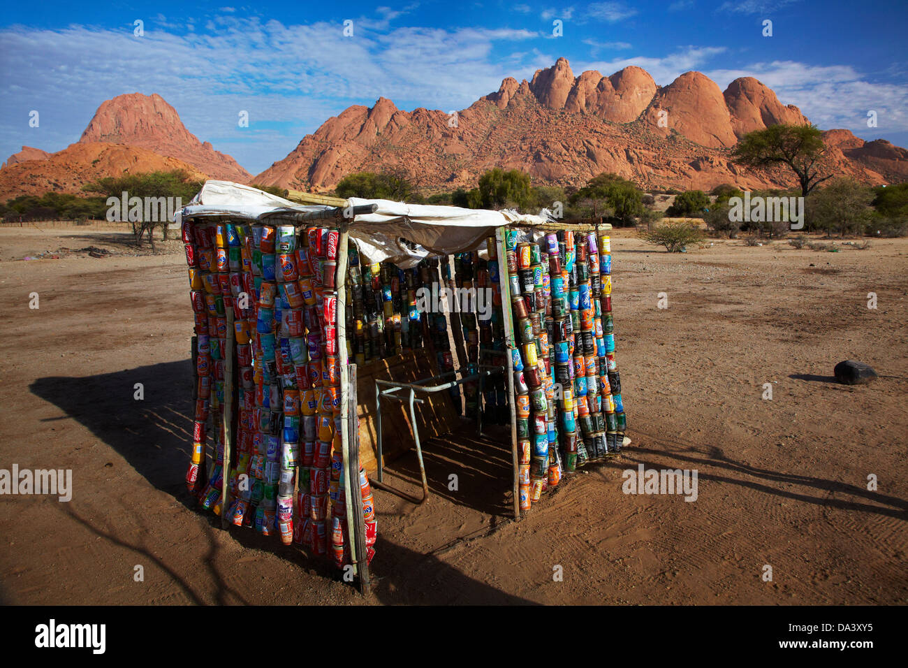 Shed made out of recycled drink cans, Spitzkoppe, and Pondok Mountains (right), Namibia, Africa Stock Photo
