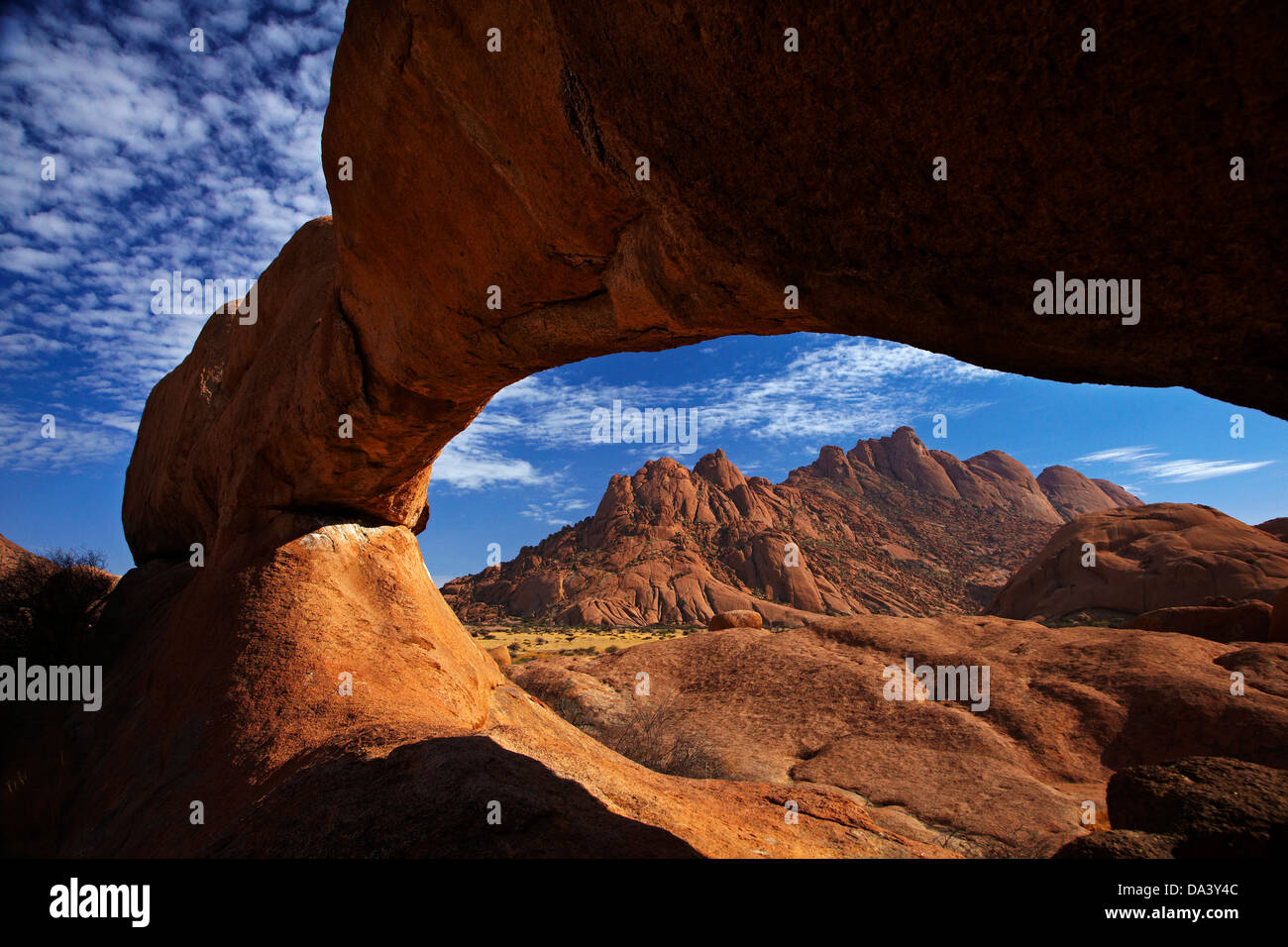 Natural rock arch at Spitzkoppe, and Pondok Mountains in distance, Namibia, Africa Stock Photo