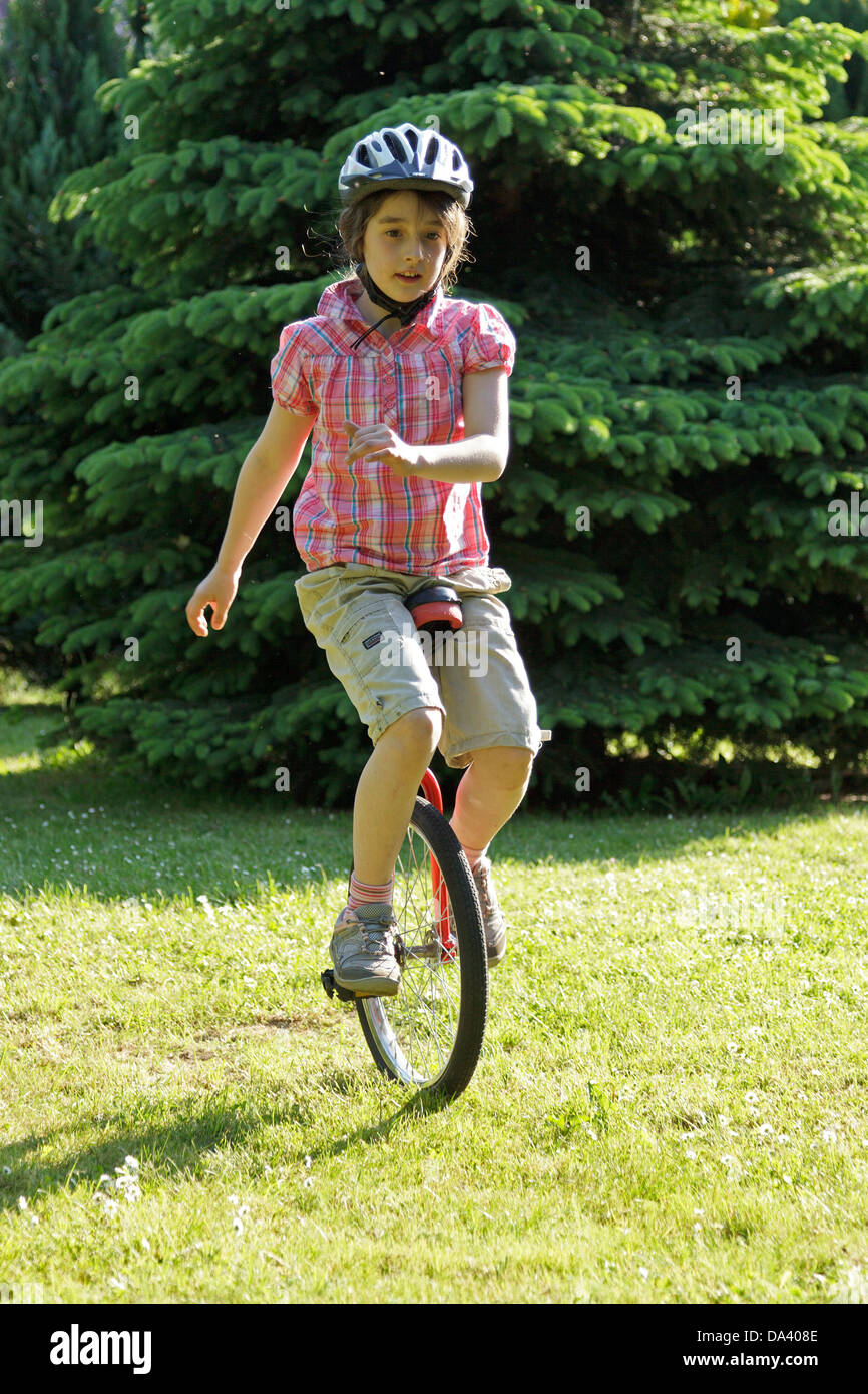 young girl on a unicycle Stock Photo Alamy
