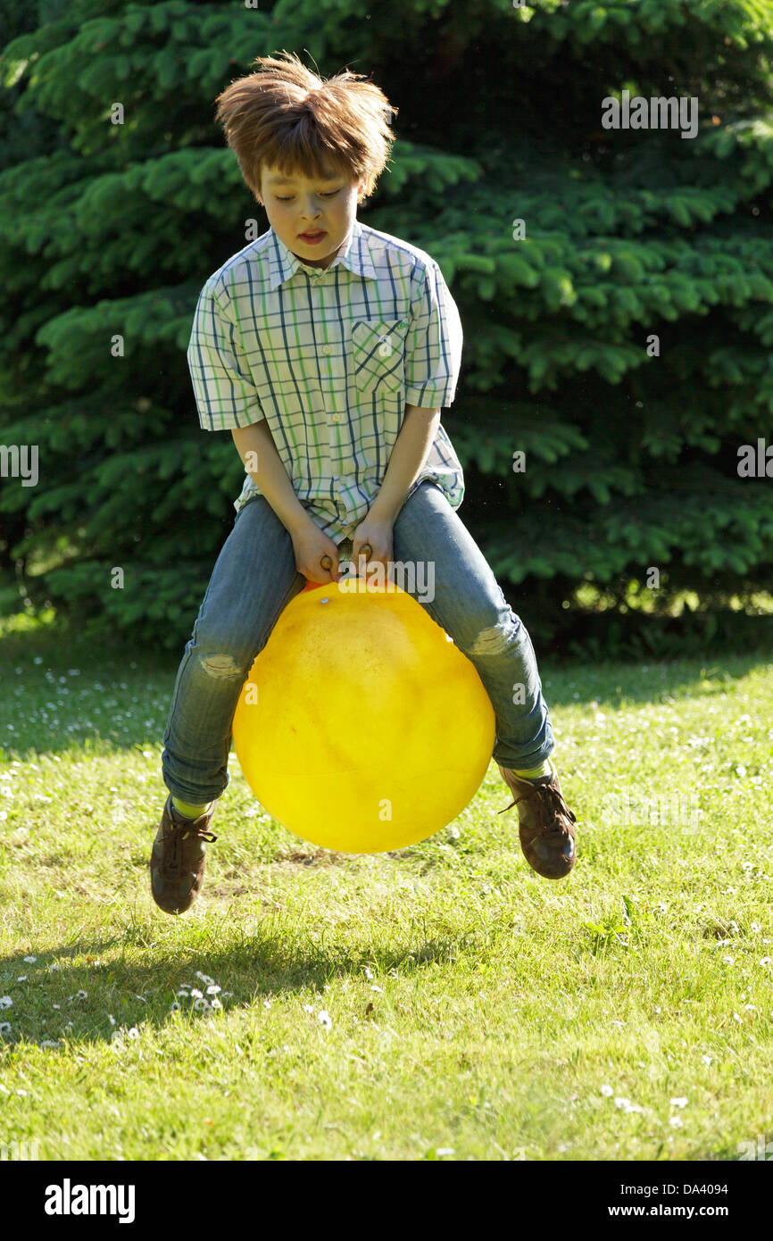 young boy hopping with a space hopper Stock Photo