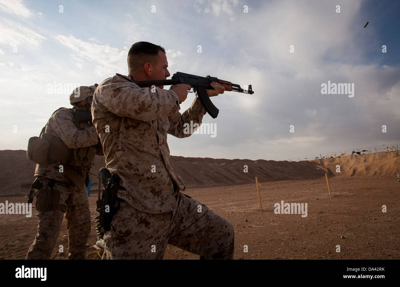 U.S. Marine Corps Sgt. Phillip Noble, right, with Regimental Combat Team 7 engages his target during a foreign weapons and NATO Stock Photo