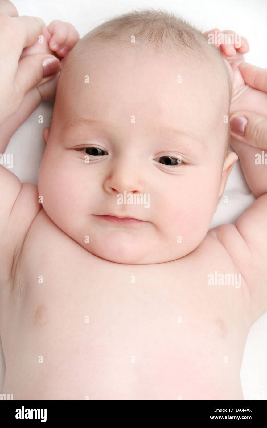 Beautiful baby on back and mother's hands Stock Photo