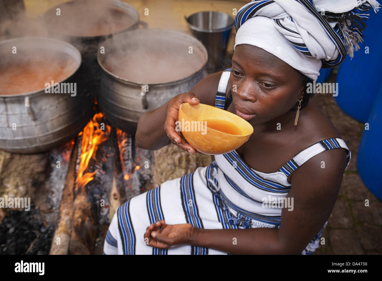 Master brewer from Burkina Faso, Ine Kam, samples her millet beer at