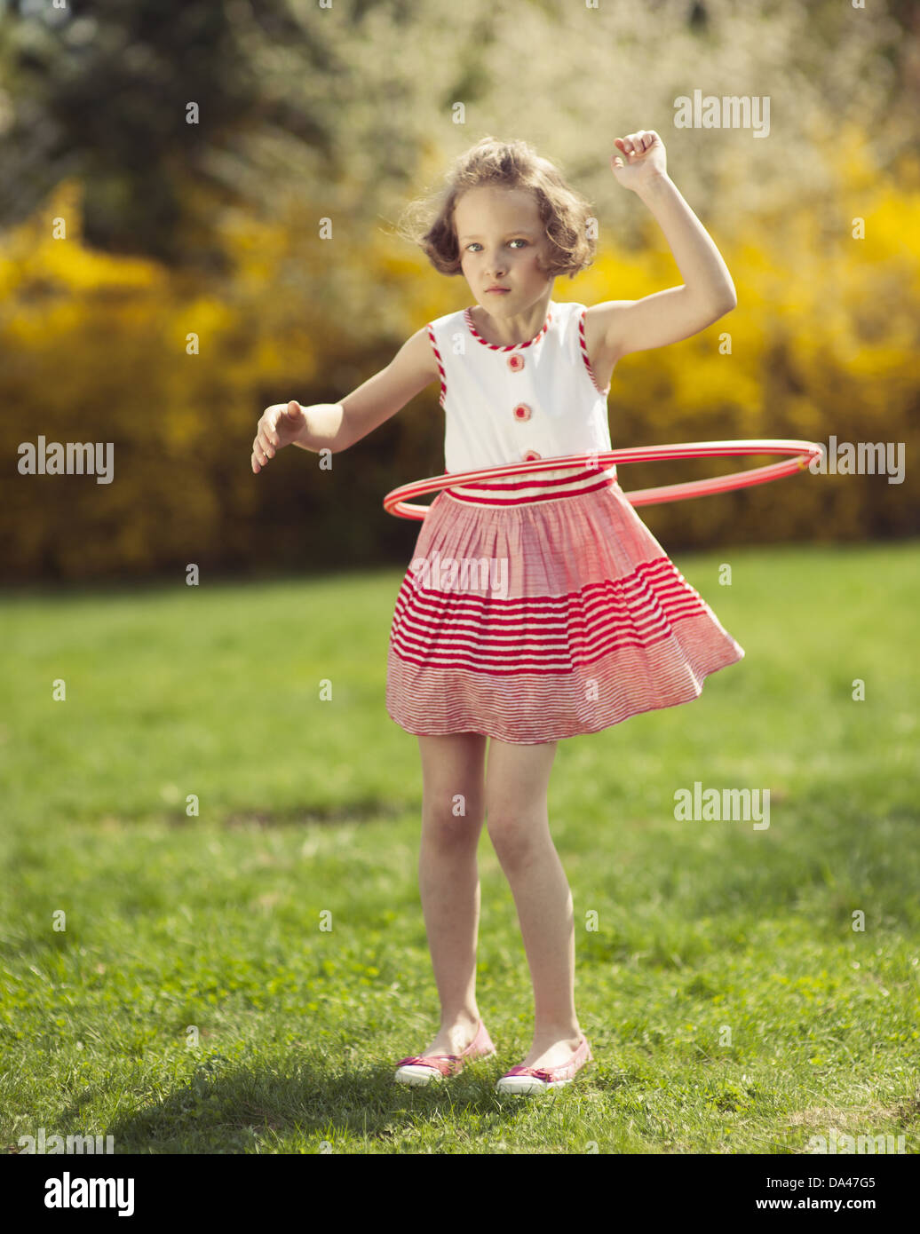 Young girl using hula hoop in a park Stock Photo - Alamy